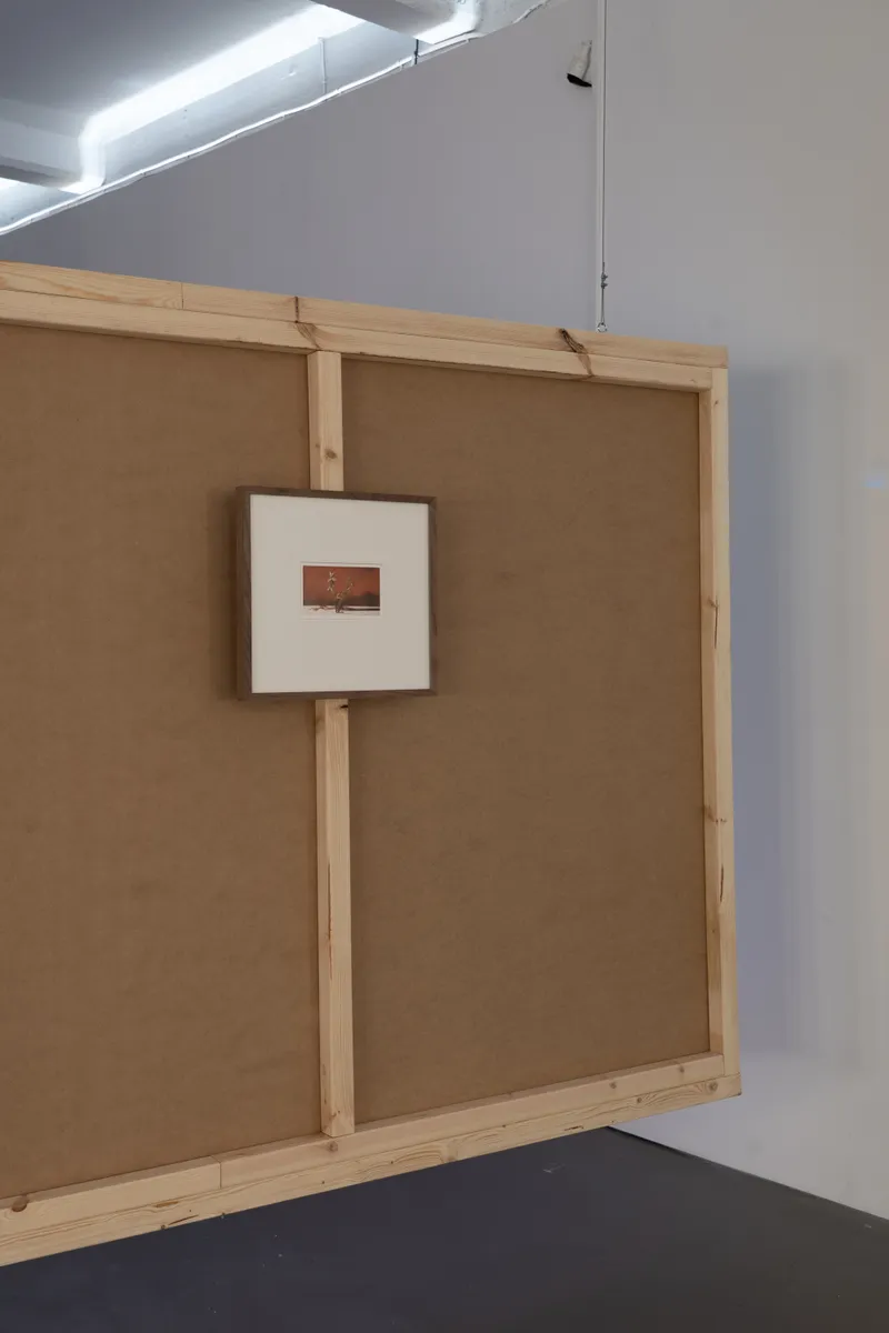A small framed image on a wooden frame covered with burlap