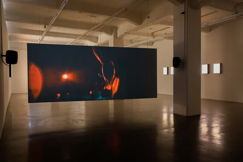 A wide screen in a dark hall showing orange light
