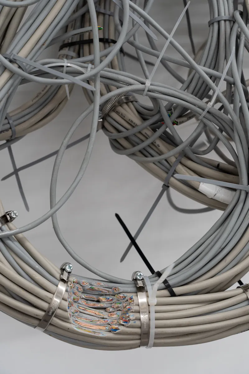 A tangle of grey cables bound with black cable ties