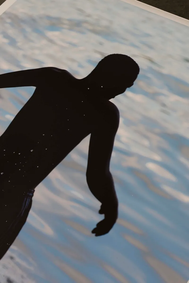 Close-up of the swimmer print, a dark figure against light water
