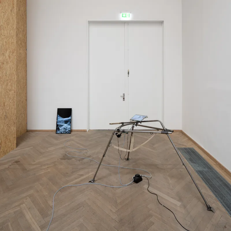 A tripod in front of a white double door, a screen leaning against the wall